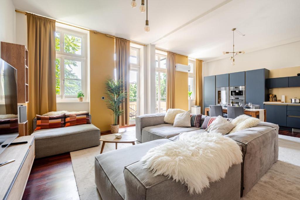 a living room with a couch and a table at EDLER WOHNRAUM Design-Loft im Graphischen Viertel 2 Schlafzimmer mit Balkon, Miele-Kaffeevollautomat, Miele-Weinkühler, Klima, Lift, Tiefgarage & WLAN 266 Mbps in Leipzig