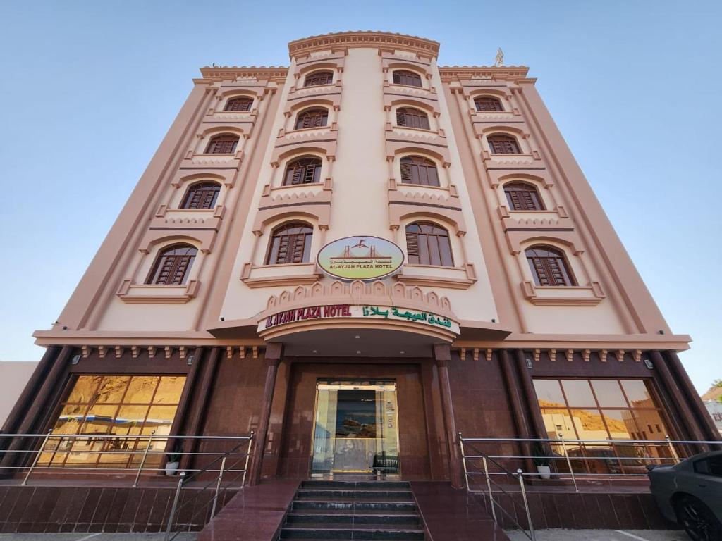 a tall building with stairs in front of it at Al Ayjah Plaza Hotel in Sur