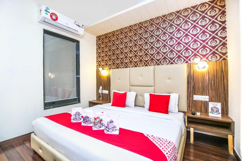 a bedroom with a large white bed with red accents at Hotel O TAJ STARS in Zirakpur