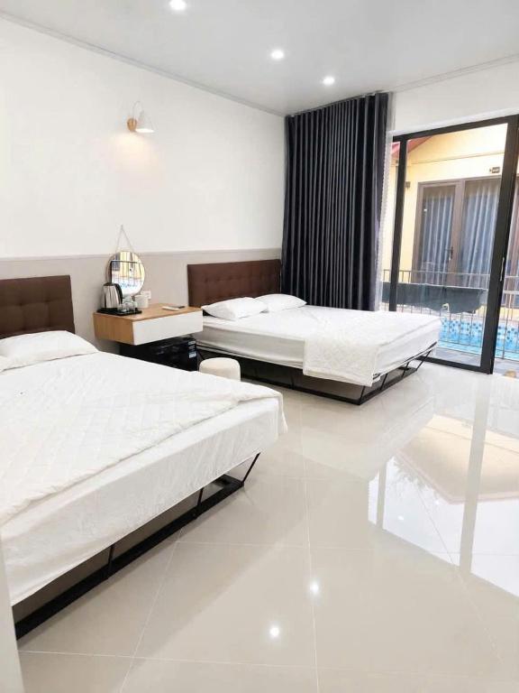 a bedroom with two beds and a large window at Minh chau riverside in Quang Ninh