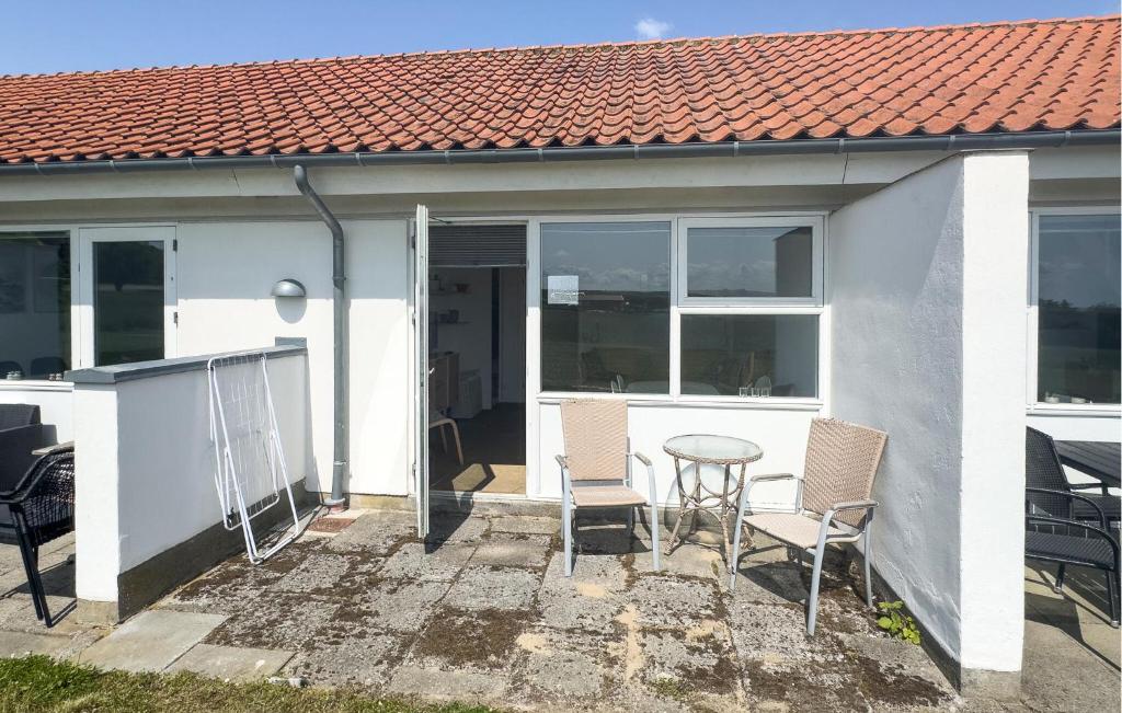 a white house with two chairs and a table at Pet Friendly Apartment In Allinge in Allinge