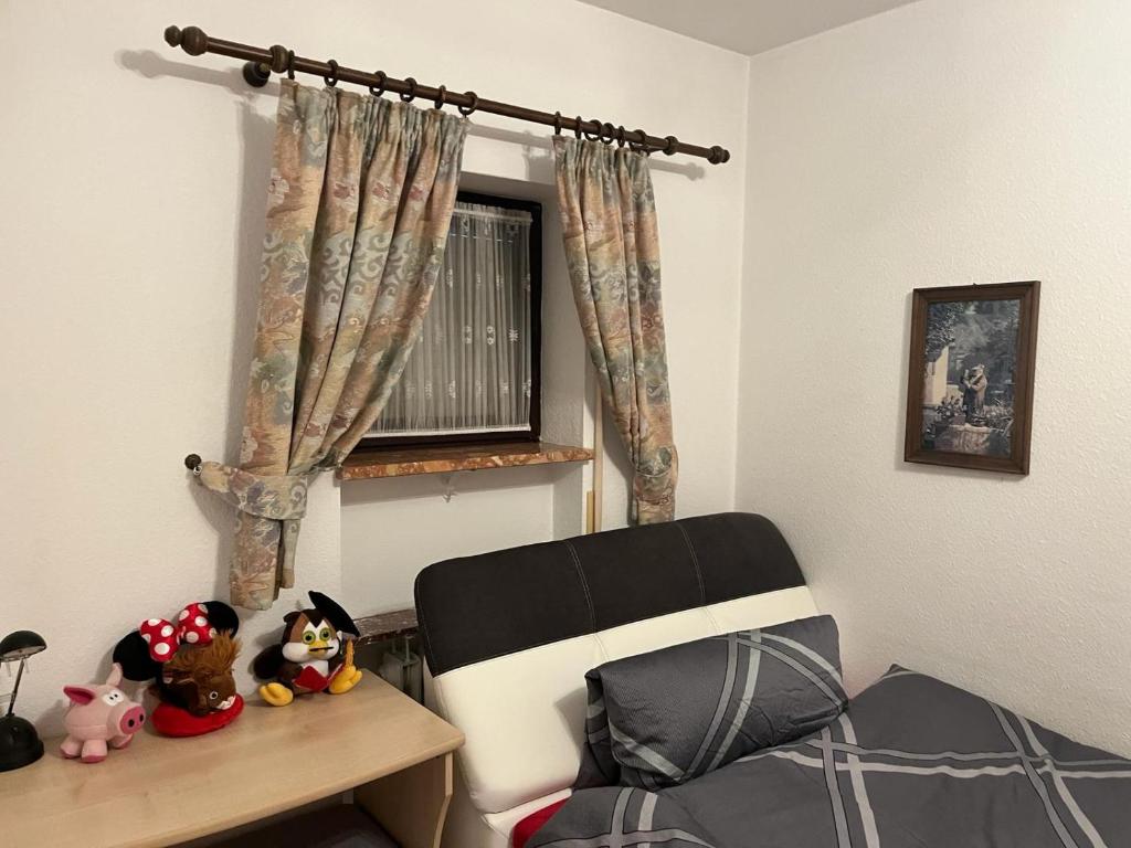a bedroom with a bed and a chair and a window at FeWo bei Charly in Herrischried