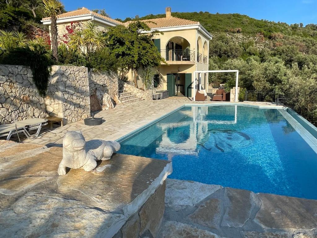 a house with a swimming pool with a teddy bear next to it at villa amouso in Évyiros