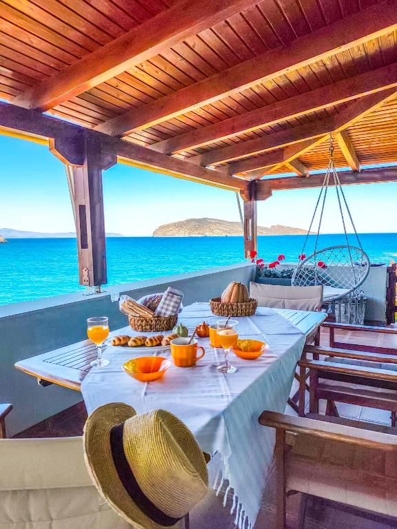 a table with a plate of food on the beach at Tholos Alexandra's Beachfront House in Kavoúsion