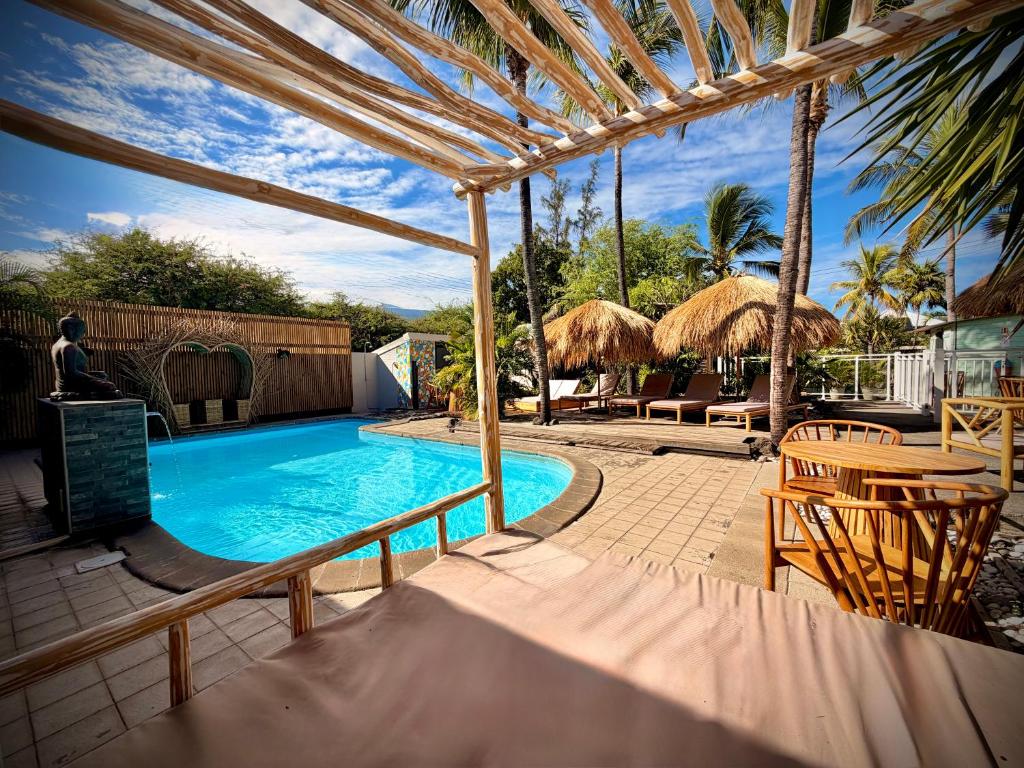 a swimming pool with a table and chairs and an umbrella at Le Vacoa in La Saline les Bains
