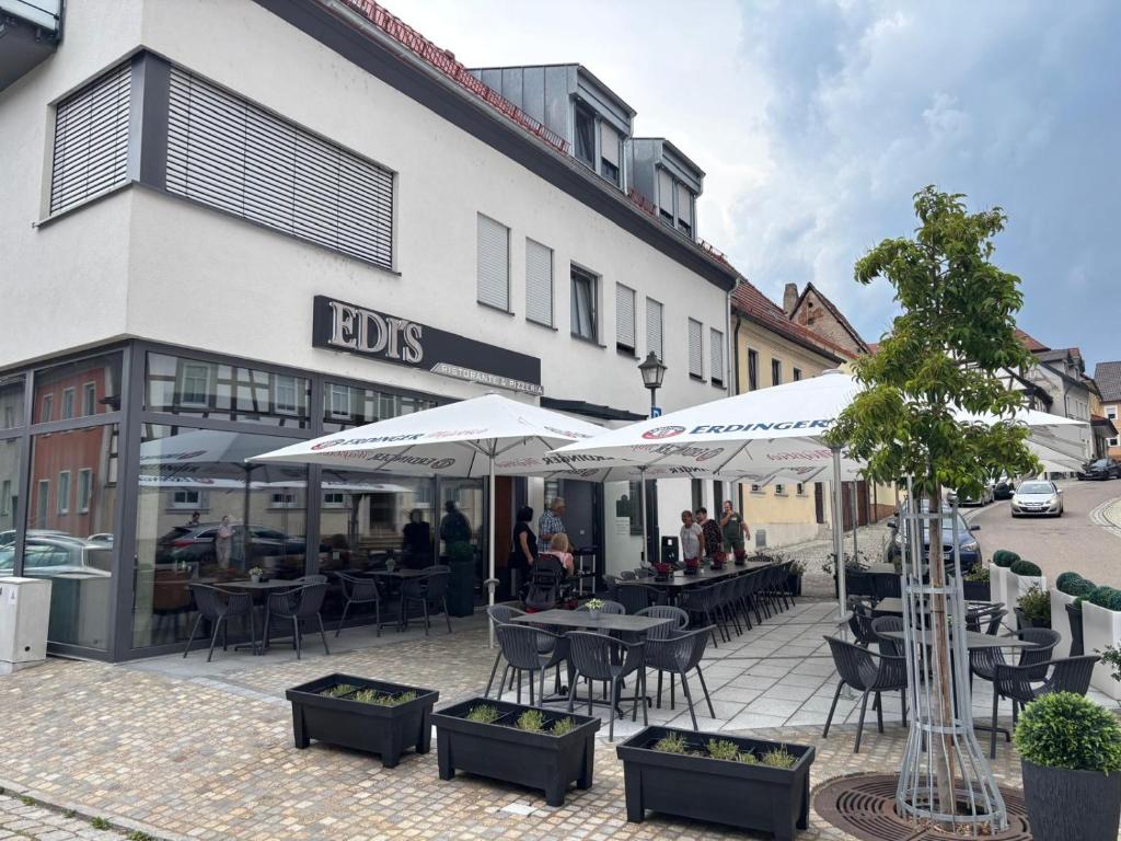a restaurant with tables and umbrellas in front of a building at Edi`s Ferienwohnung in Eltmann