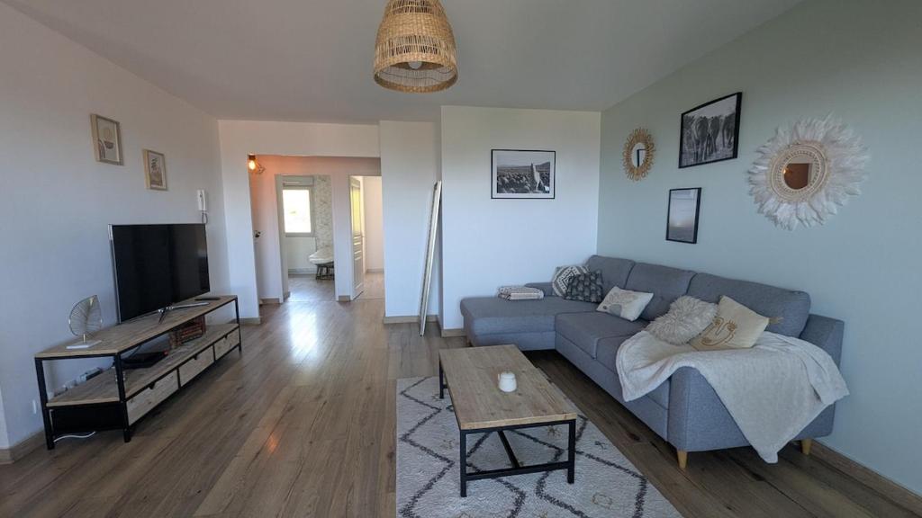 a living room with a blue couch and a tv at Cozy apartment with exceptional view in Gex