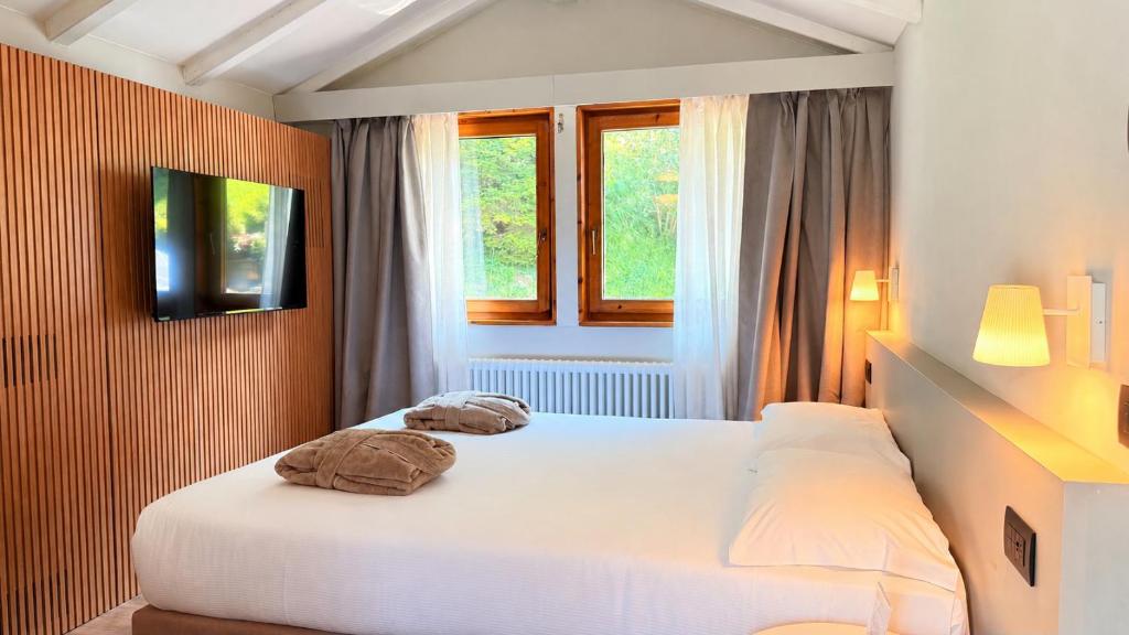 a bedroom with a bed with two towels on it at Alchimia WellResort in Comano Terme