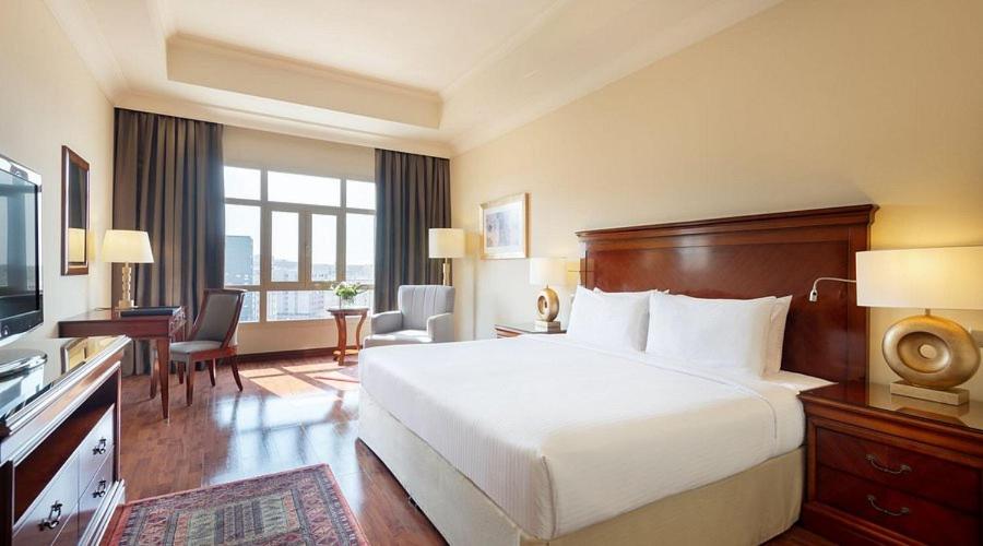 a hotel room with a bed and a television at Assala Hotel in Faisalabad
