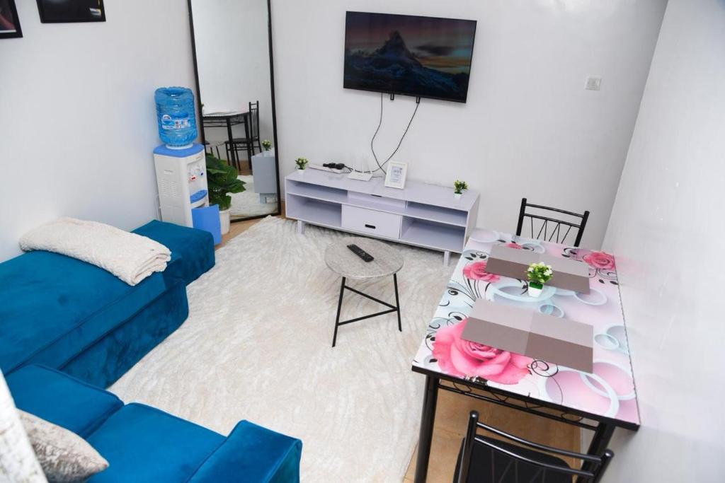 a living room with a blue couch and a table at SJ Homes II in Eldoret