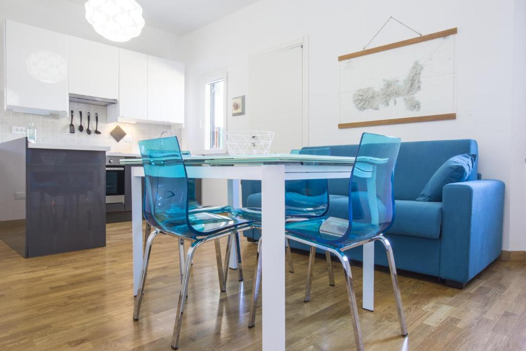 une cuisine avec une table à manger et des chaises bleues dans l'établissement Nila Apartment, à Porto Azzurro