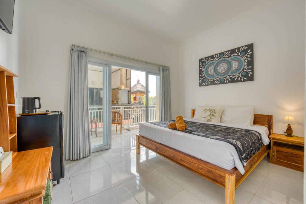 a bedroom with a bed and a balcony at narayuka house in Seminyak