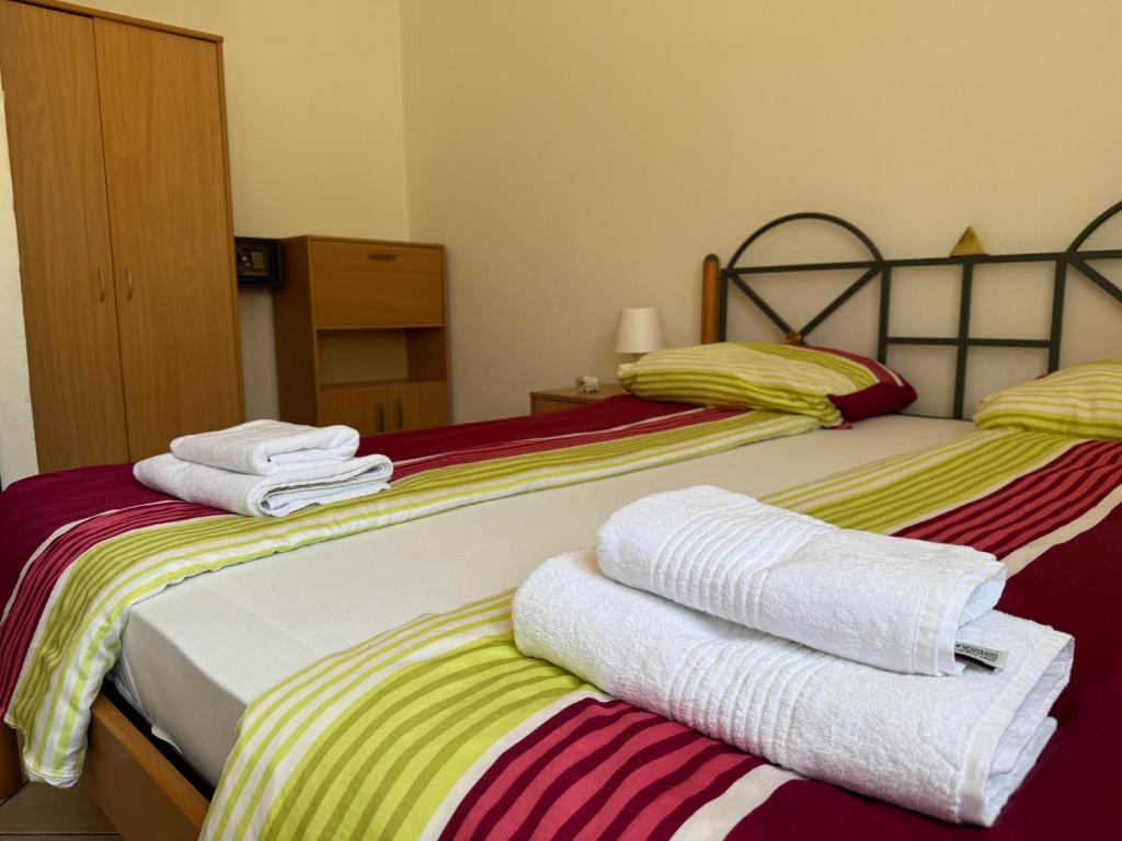 two beds with towels stacked on top of each other at Green House Villa with Pool in Banjole