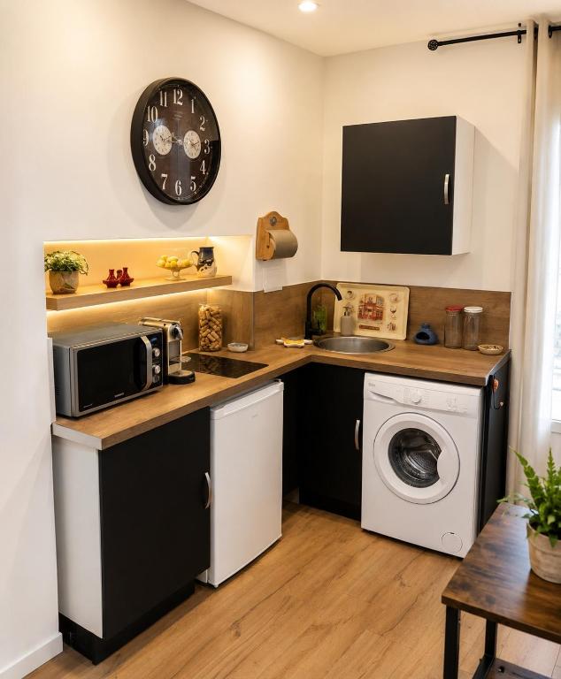 a kitchen with a microwave and a washing machine at L'Instant Parfumé in Grasse