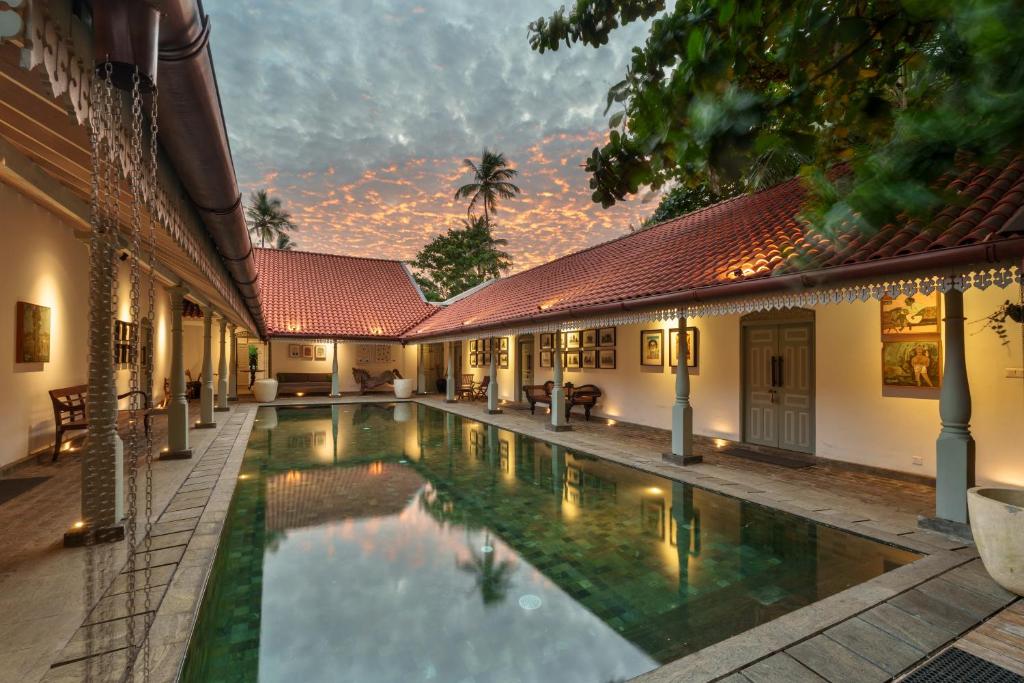 a swimming pool in the courtyard of a house at Indigaslanda Walawwa in Bopitiya