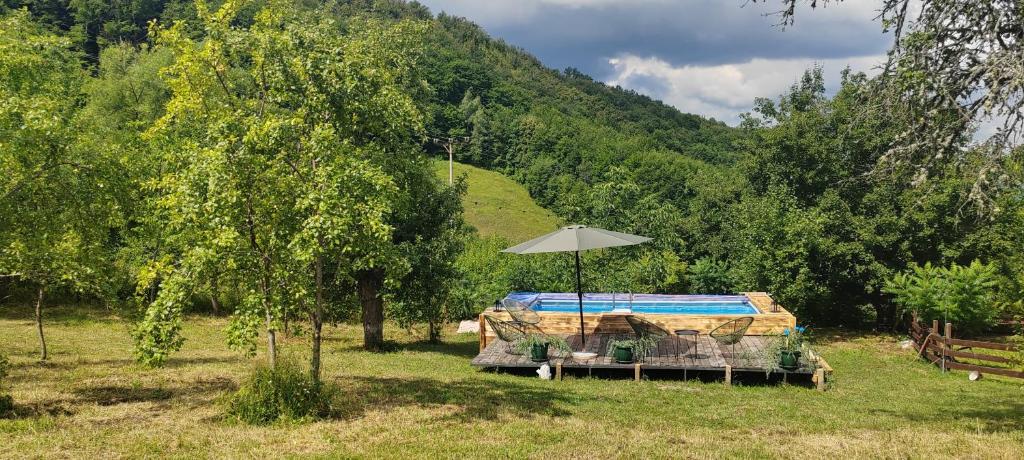 a table with an umbrella in a field at Konak ispod Subjela in Ševrljuge