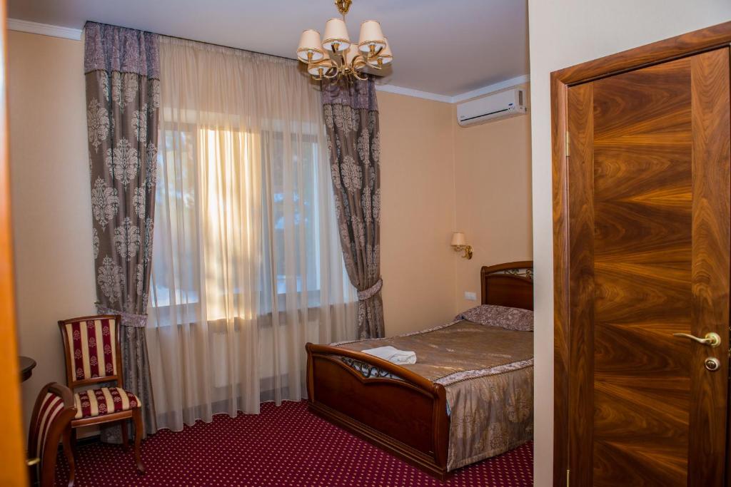 een kleine slaapkamer met een bed en een raam bij Старый Симбирск in Ulyanovsk