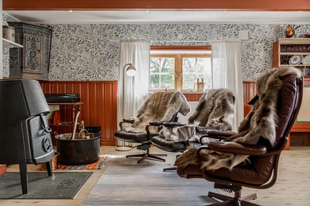 a living room with three chairs and a tv at Hemgården i Storsätern - Grövelsjöfjällen in Grövelsjön