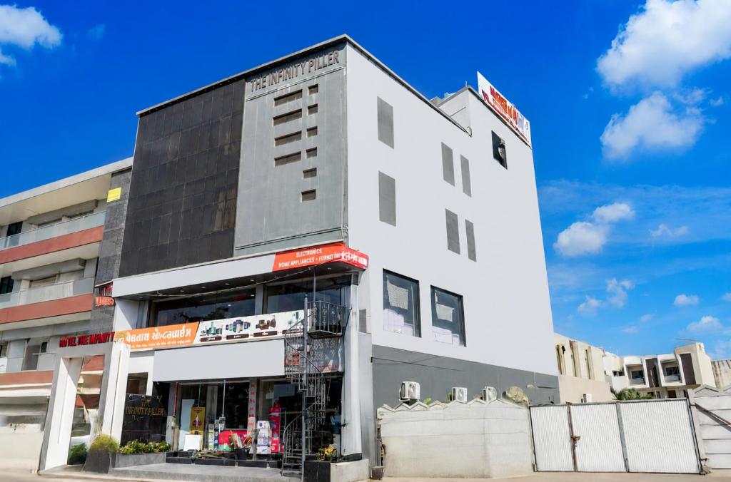 a white building with a store in front of it at Hotel the Infinity in Rajkot