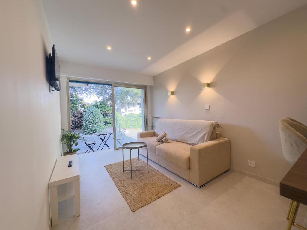 a living room with a couch and a table at Sublime apartment - Beachfront in Saint-Laurent-du-Var