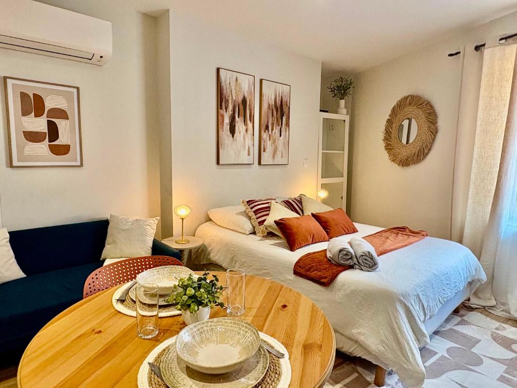 a living room with a bed and a table at Le Cocon d'Or - Hyper centre - Clim - WIFI in Toulouse