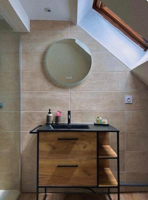 a bathroom with a sink and a mirror at L'instant Cosy in Gamaches