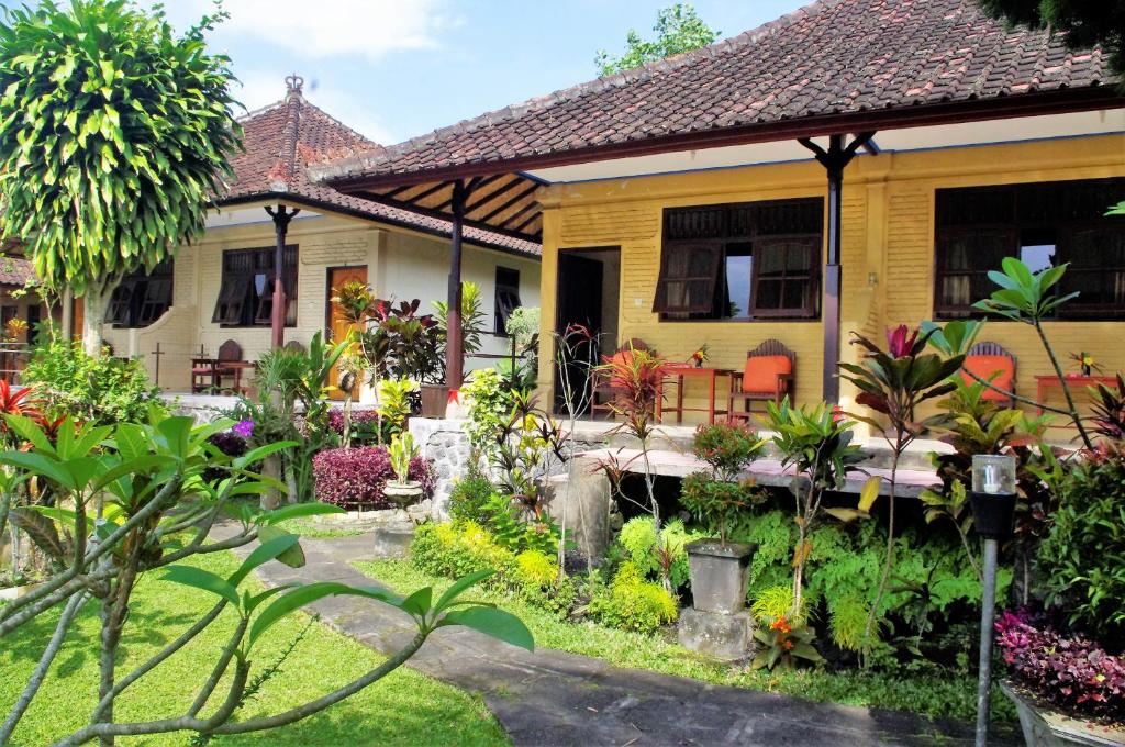 a house with a garden in front of it at Rijasa Homestay in Tirtagangga