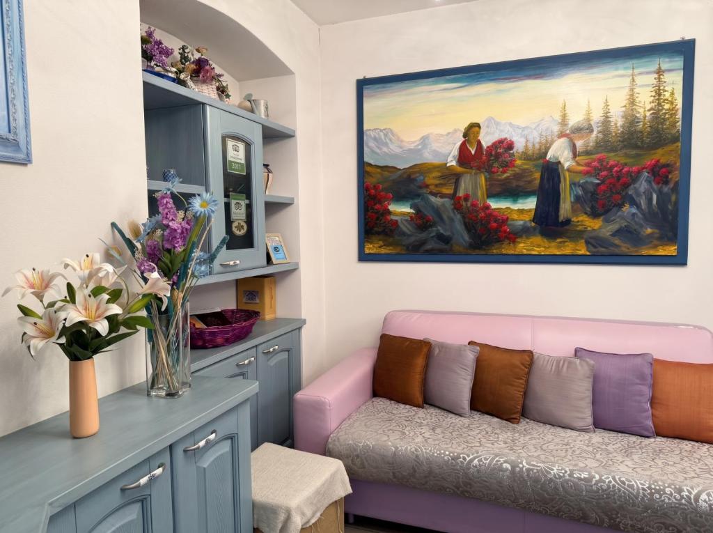 a living room with a couch and a painting on the wall at Settimo Cielo in Grosio