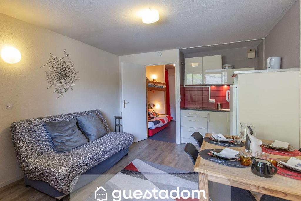 a living room with a couch and a kitchen at La Mongie Parking Petfriendly in Bagnères-de-Bigorre