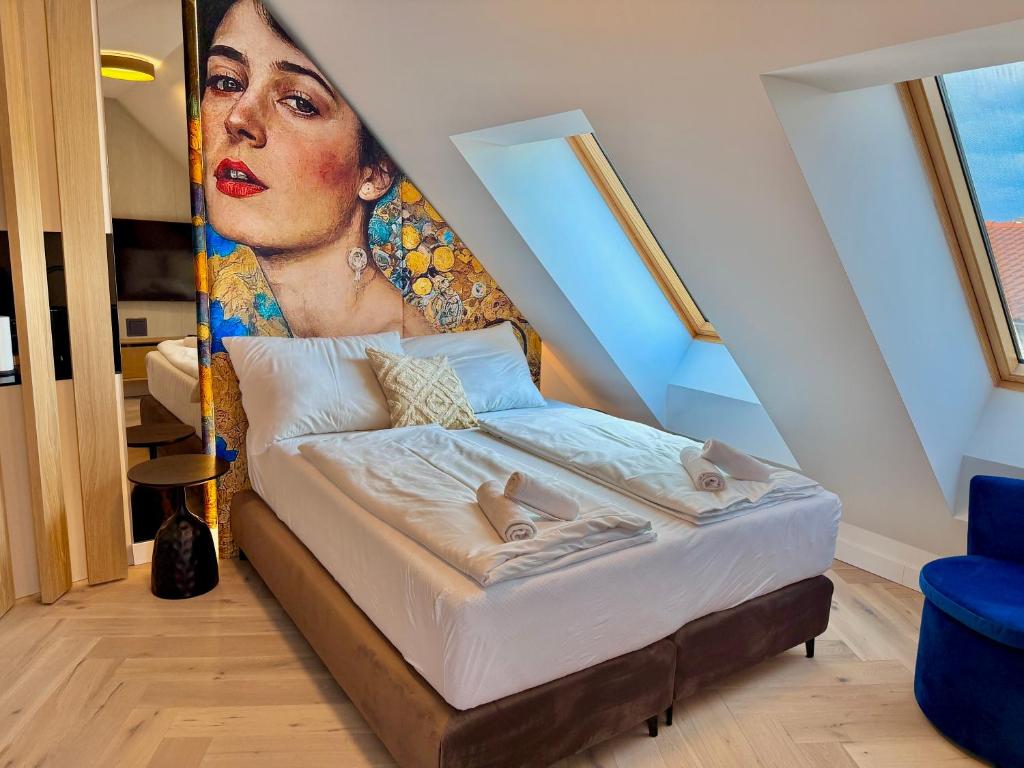 a room with a bed with a painting of a woman at Rooftop Deluxe Apartment LEGRAND in Vienna