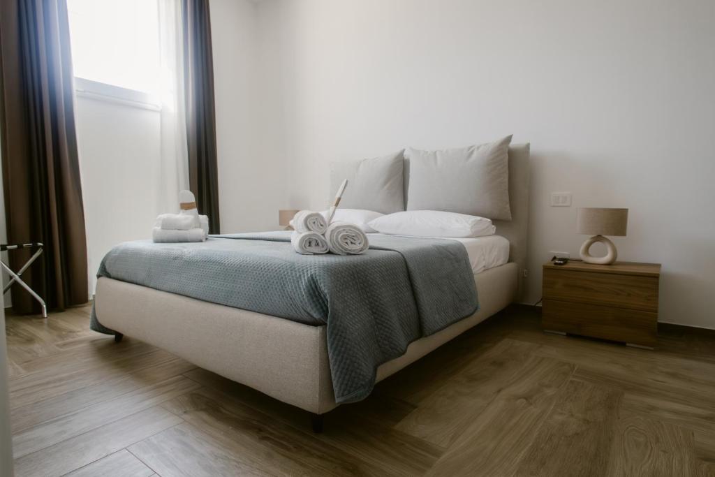 a bedroom with a bed with two towels on it at Erigia House - Appartamenti Eleganti - Molfetta in Molfetta