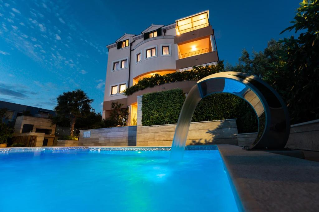 a building with a swimming pool in front of a building at Villa Žnjan in Split