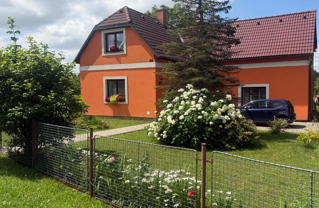 an orange house with a fence in front of it at Apartmán Bystré in Bystré