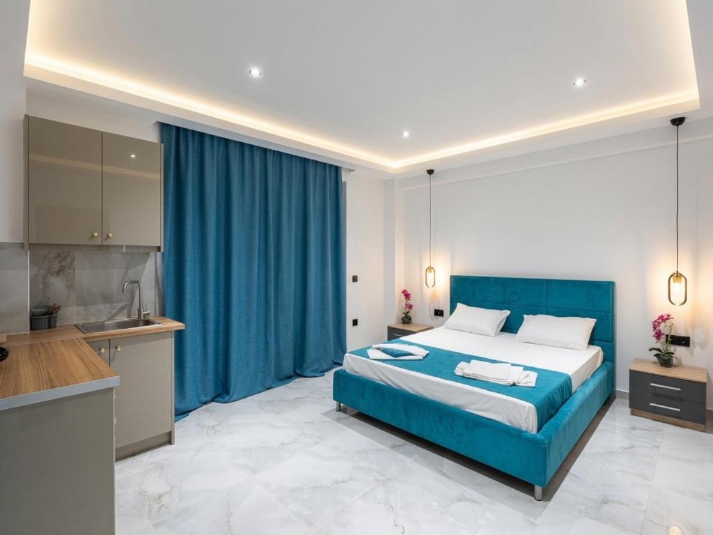 a bedroom with a blue bed and a kitchen at Central Luxury Rooms in Alikanas