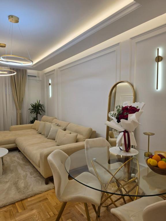 a living room with a couch and a glass table at Stan na dan Podgorica Mne in Podgorica