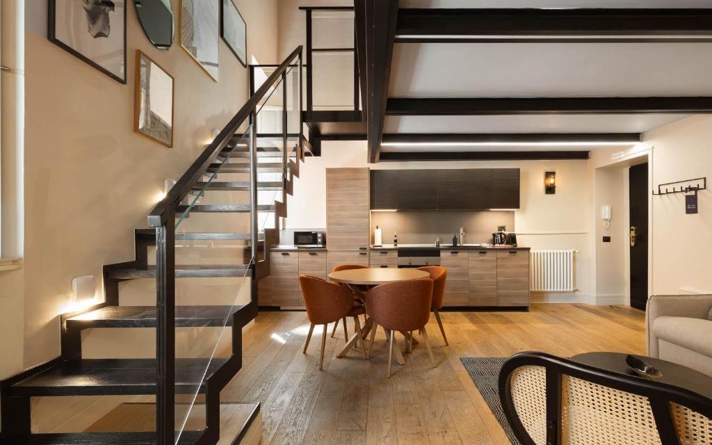 a living room with a staircase and a table and chairs at Limehome Rome Trastevere in Rome