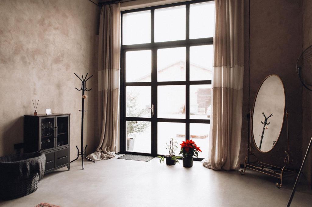 a room with a large window and a mirror at Maruse's Apartment in Kuldīga