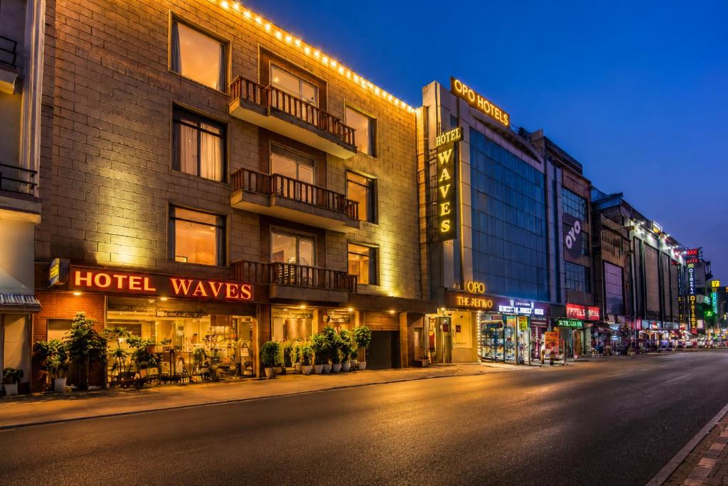 a city street at night with a hotel at The Waves Hotel with Free Airport Pickup or Drop in New Delhi