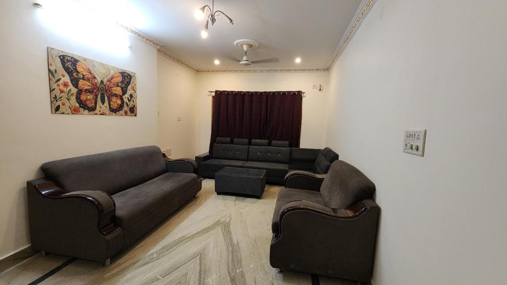 a living room with a couch and two chairs at BMK Inn in Bangalore