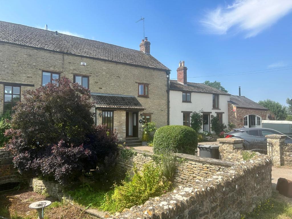 a house with a stone wall and a yard at Astwell Mill Private accommodation near Silverstone in Helmdon