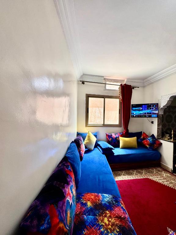 a living room with a blue couch and a red rug at Romantic apartment near sea in Safi, Morocco in Safi