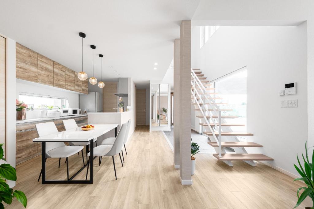 a kitchen and dining room with a white table and chairs at The Prestige in Asahikawa