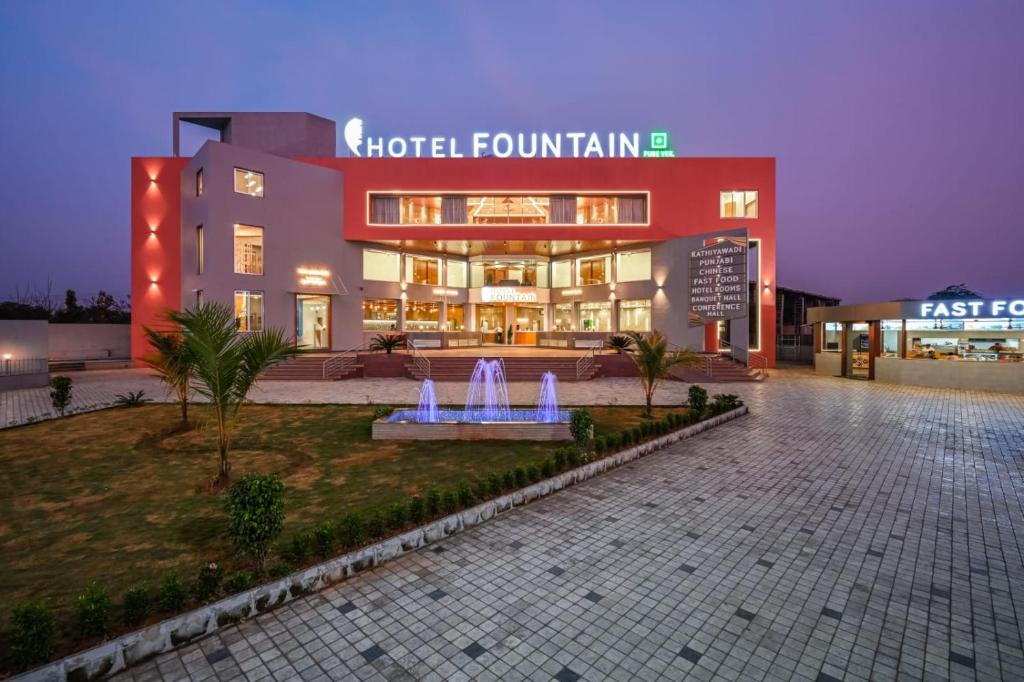 a building with a fountain in front of it at Hotel Fountain - Kamrej in Surat