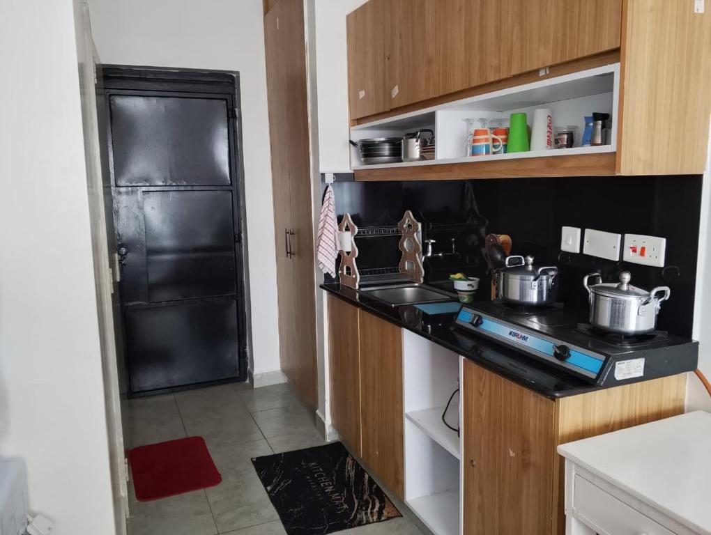 a small kitchen with a stove and a sink at Tsavo in Nairobi