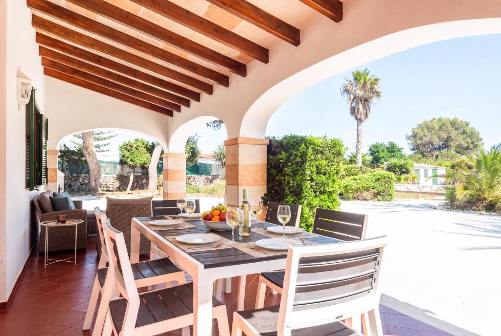 a dining room with a table and chairs on a patio at Casa Carlos - Villa en Son Cabrises in Cala Blanca