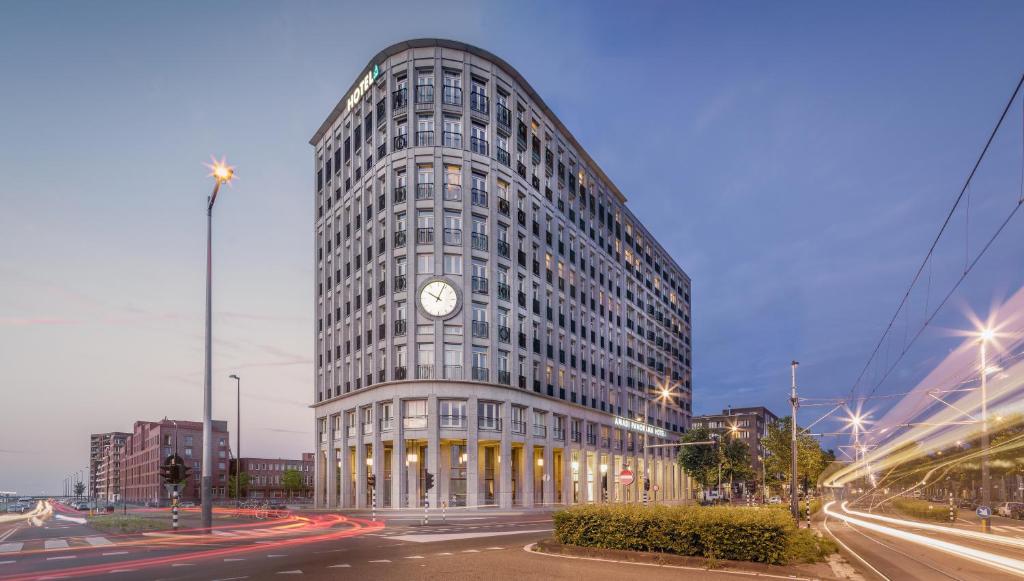 um edifício alto com um relógio na lateral em Amadi Panorama Hotel em Amsterdã
