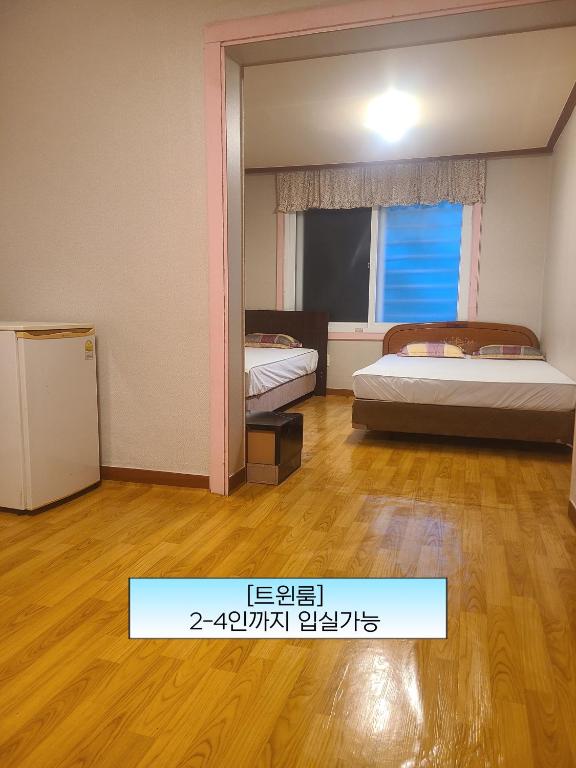 a room with two beds and a mirror at Sorak Garden Resortel in Sokcho