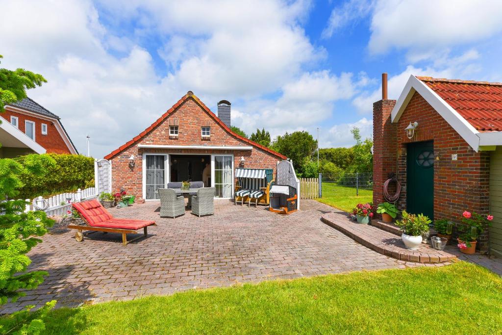 a brick yard with a brick house and a patio at Ferienhaus Sternenklar in Wittmund