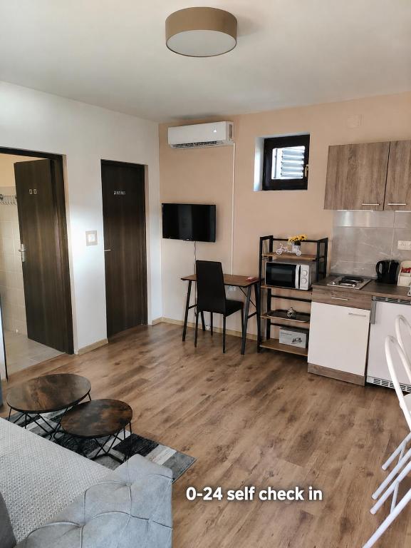 a living room with a table and a kitchen at Apartman LIPA-Lipovac Bajakovo! Parking,Wi-Fi in Lipovac