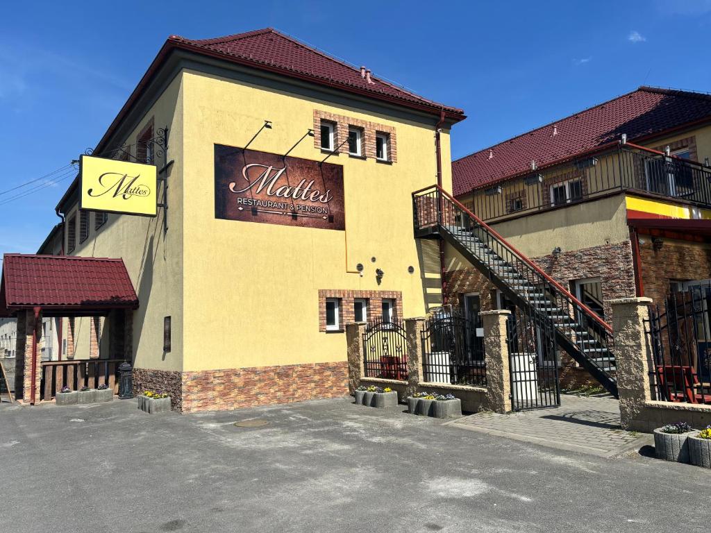 a building with a sign on the side of it at Mattes Restaurant & Pension in Držovice
